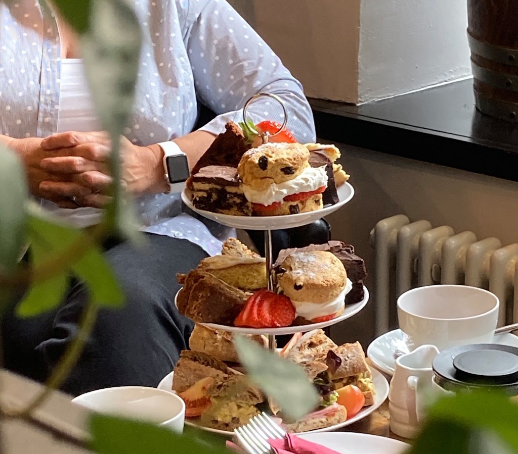 Afternoon tea stand with sandwiches, scones and cakes