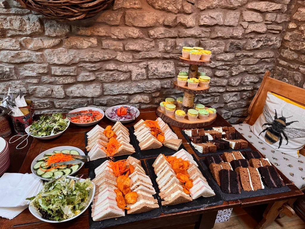 Buffet table with sandwiches, salads, cupcakes and cakes